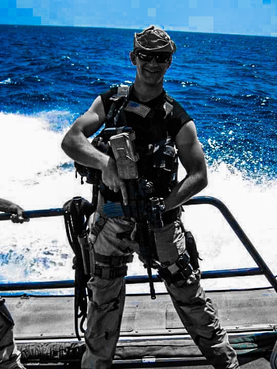 Justin Myers armed and ready on patrol boat