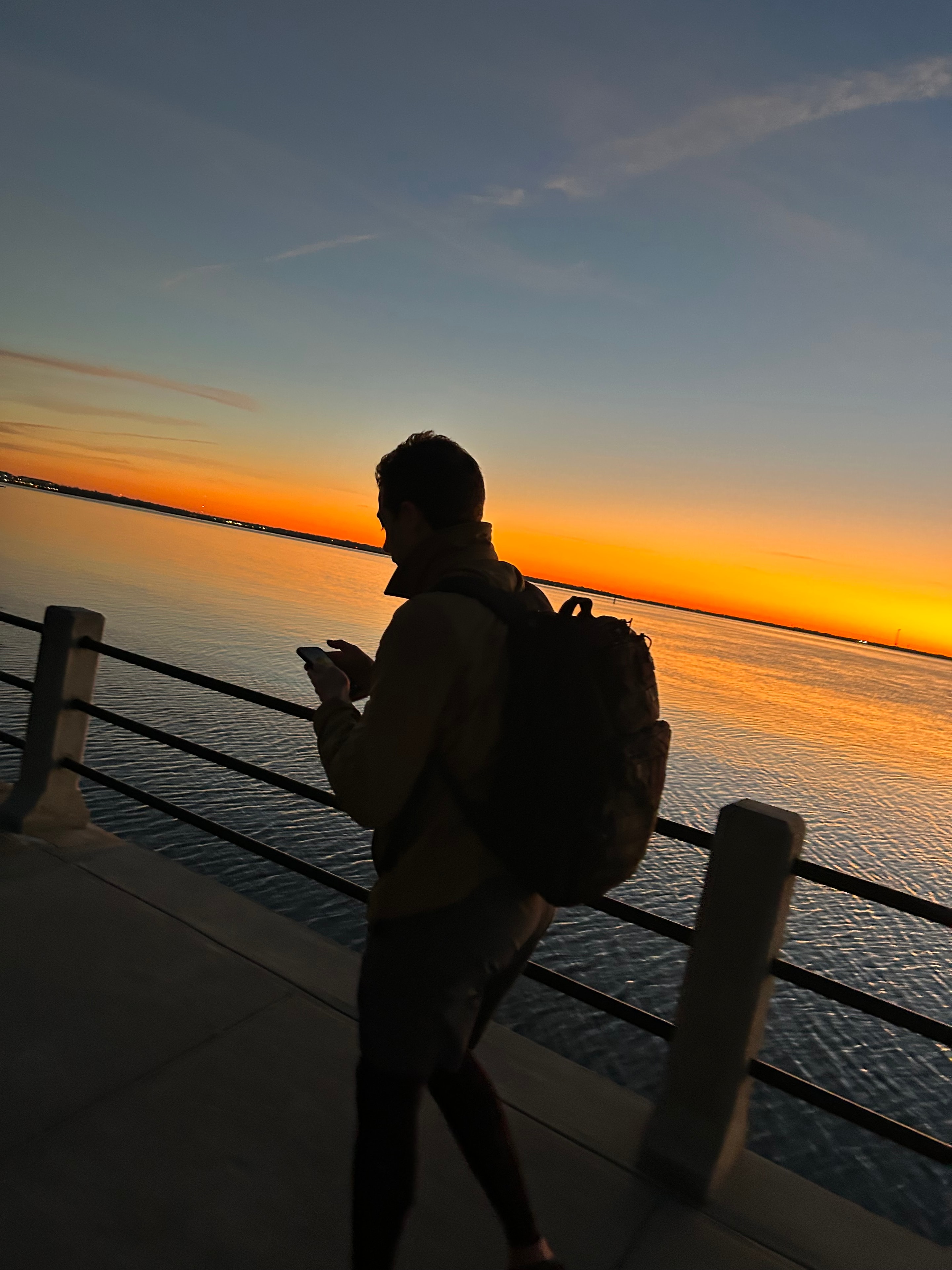Silhouette of a rucker at sunset on the water